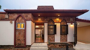 A house with a brick facade, a tiled roof, and a front entrance with a door and windows. - Balinese 3BR Pool Villa Freya in Rawai (Rawai)