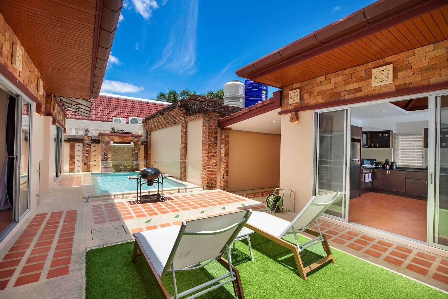 A backyard with a pool, a barbecue grill, and a dining area with chairs.