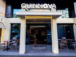The entrance to the Quinnova Hotel with a modern design, featuring a prominent sign and outdoor seating area. - Quinnova Hotel (Istanbul)