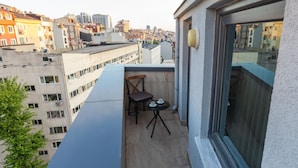 A balcony with a table and chairs, overlooking a cityscape. - Quinnova Hotel (Istanbul)