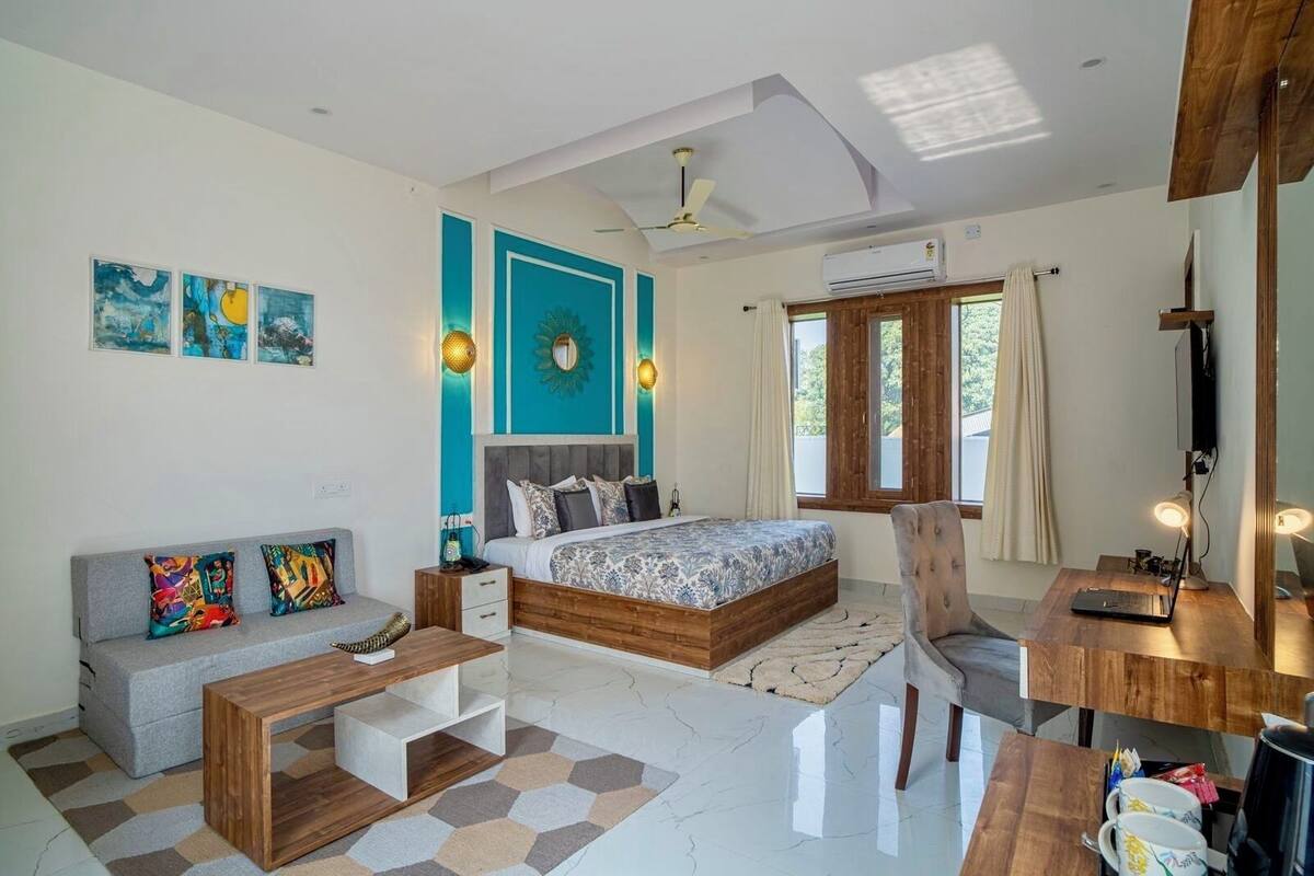 Un dormitorio moderno con cama, sofá, escritorio y ventilador de techo.