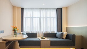 A modern hotel room with a sofa set, a small table, and a vase with flowers. - Rezen Longuu Hotel - Guangzhou Baiyun Airport Cultural Tourism City (Guangzhou)
