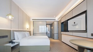 A modern hotel room with a bed, bedside table, and a TV mounted on the wall. - Rezen Longuu Hotel - Guangzhou Baiyun Airport Cultural Tourism City (Guangzhou)