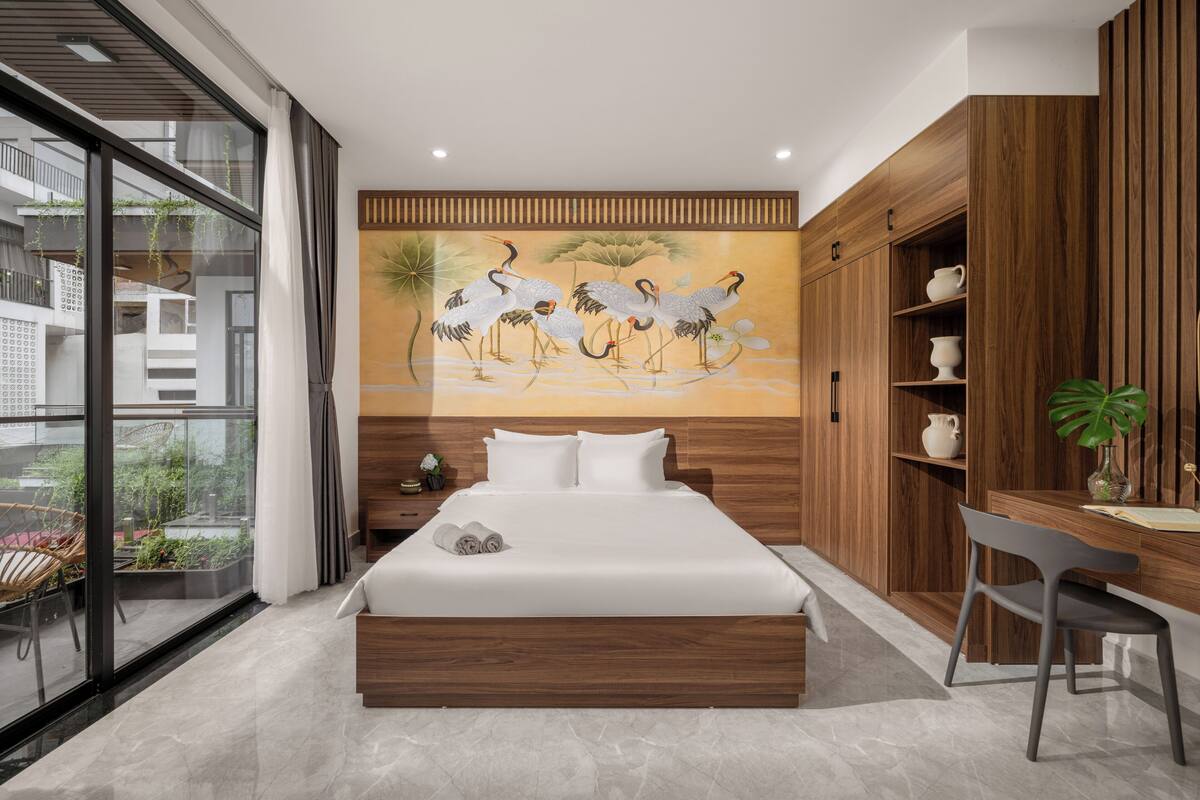 Une chambre moderne avec un grand lit, une armoire en bois et une fresque représentant des grues.