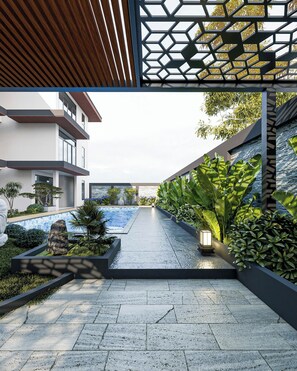 A modern outdoor area with a pool, stone pathway, and lush greenery. - CiCi Villa & Apartment (Da Nang)