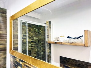 A bathroom with a glass shower, a wooden shelf with toiletries, and a tiled wall. - SAINT JOHN HOUSE ROME only 10 minutes by subway from the historic center of Rome (Roma)