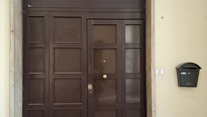A large, dark brown double door with a metal handle and a mail slot on the right side.