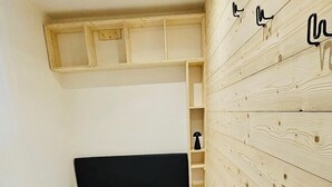 Une chambre à coucher avec un lit, un lambris en bois, une étagère intégrée et un luminaire au plafond.