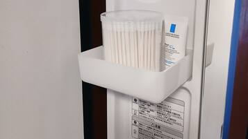 A white shelf with a container of cotton swabs and a box of tissues.
