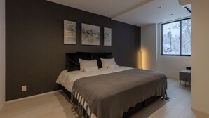 A modern bedroom with a large bed, dark walls, and three abstract paintings. - Origami Twins (Hakuba)