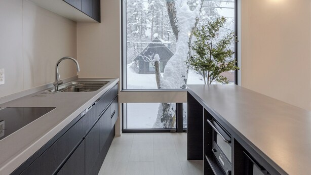 A modern kitchen with a large window, stainless steel appliances, and a minimalist design. - Origami Twins (Hakuba)