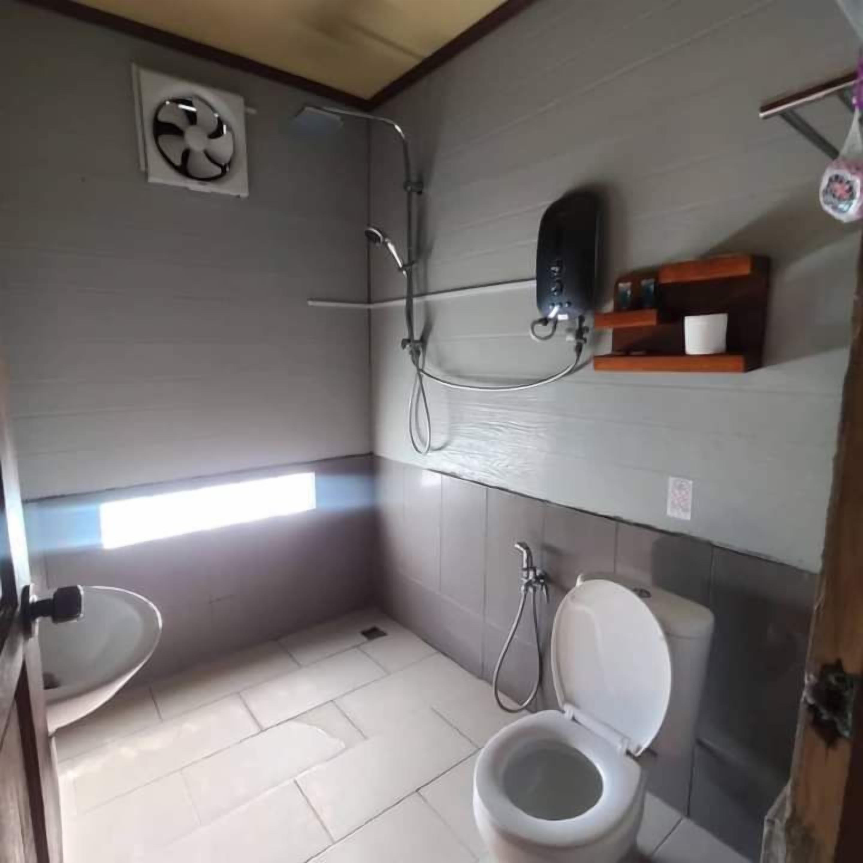 A small bathroom with a toilet, a shower, and a sink.