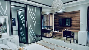 Une chambre à coucher moderne, comprenant un lit, un bureau, une chaise, une télévision et une armoire.