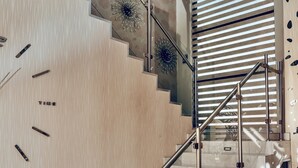 Un escalier moderne avec des marches en bois et une rampe en métal, menant à un niveau inférieur.