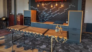 Une cuisine moderne dotée d’un plan de travail en bois, d’un évier et d’un dosseret en carreaux hexagonaux.