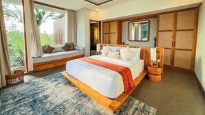 A bedroom with a large bed, a window seat, and a view of greenery. - Villa Suarga Des Anicca (Ubud)