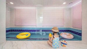 A child in a pool with inflatable rings, a toy boat, and a fish. - Gapyeong Laonjena Pool Villa (Gapyeong)