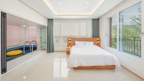 A modern bedroom with a large bed, a glass-enclosed pool area, and a balcony with a view. - Gapyeong Laonjena Pool Villa (Gapyeong)