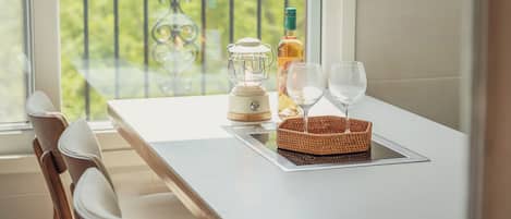 A balcony with a table, a table lamp, a bottle, and two glasses.