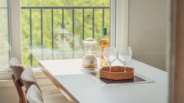 A balcony with a table, a table lamp, a bottle, and two glasses. - Gapyeong Laonjena Pool Villa (Gapyeong)