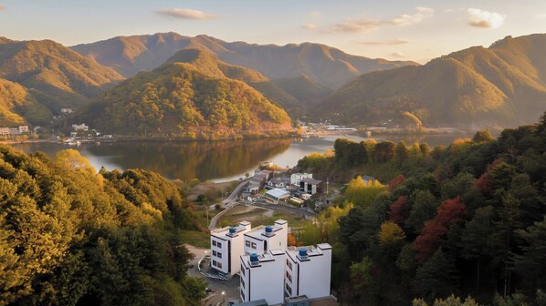 A lakeside town with buildings and mountains in the background.