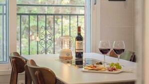 A dining table with a bottle of wine, two glasses of red wine, a candle, and a selection of snacks. - Gapyeong Laonjena Pool Villa (Gapyeong)