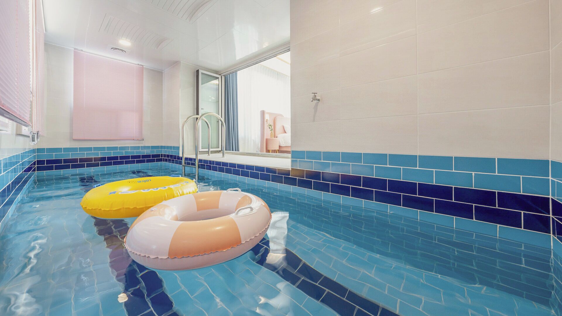 Ein Hallenbad mit blauen Fliesen und zwei aufblasbaren Schwimmreifen.