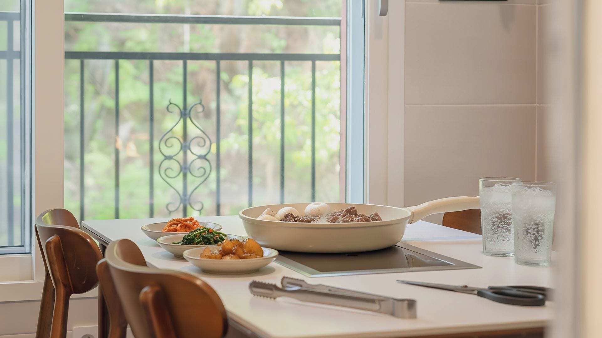 Una mesa de comedor con platos de comida, un tazón de huevos y una tetera.