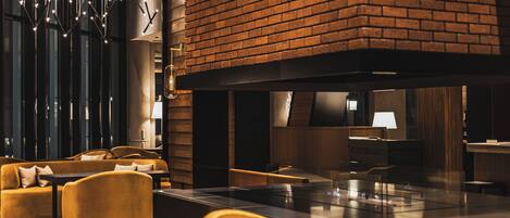 Un interior moderno con sofás, chimenea y una zona de bar.