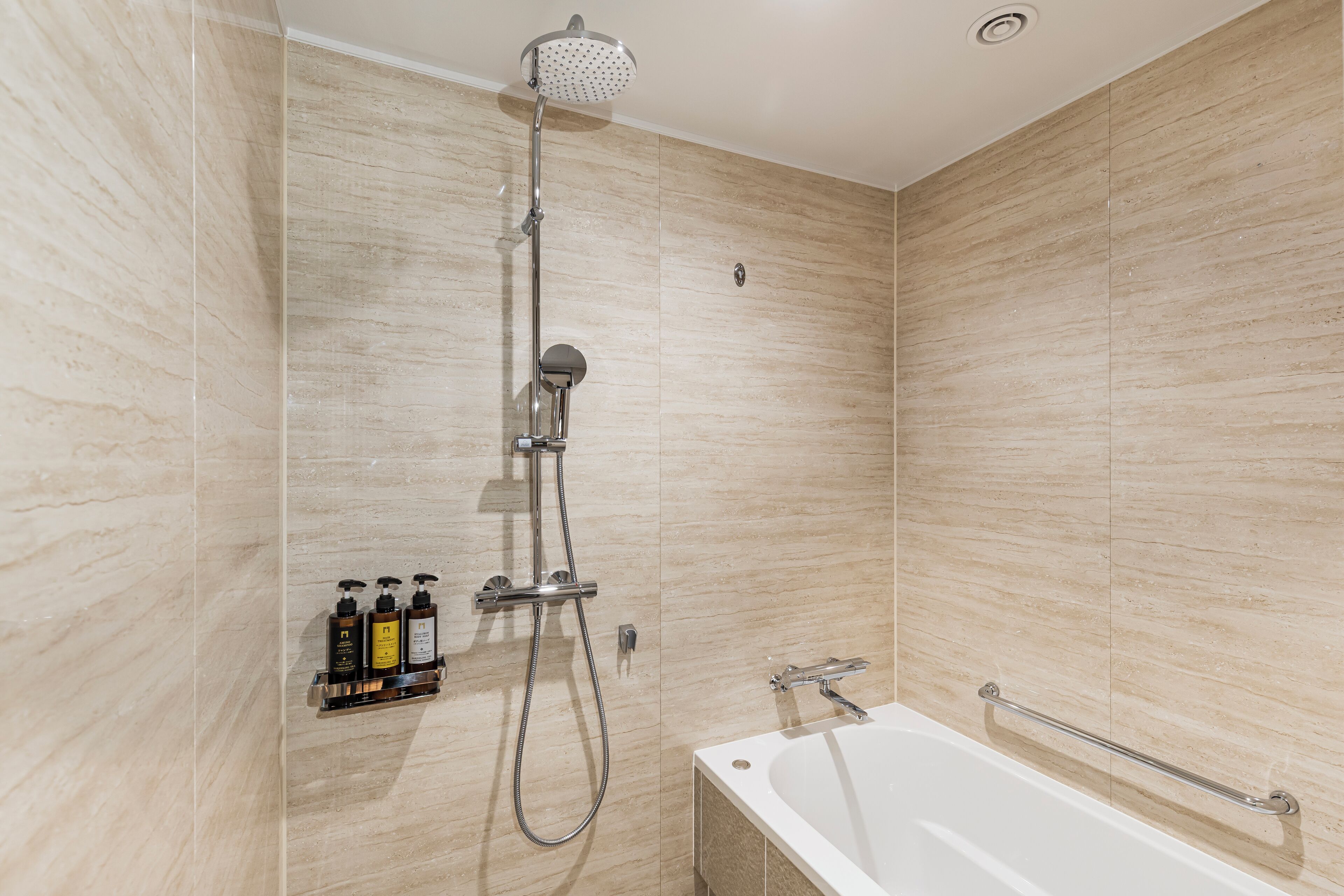 Une salle de bain moderne équipée d’une douche, d’une baignoire et d’une étagère pour les articles de toilette.