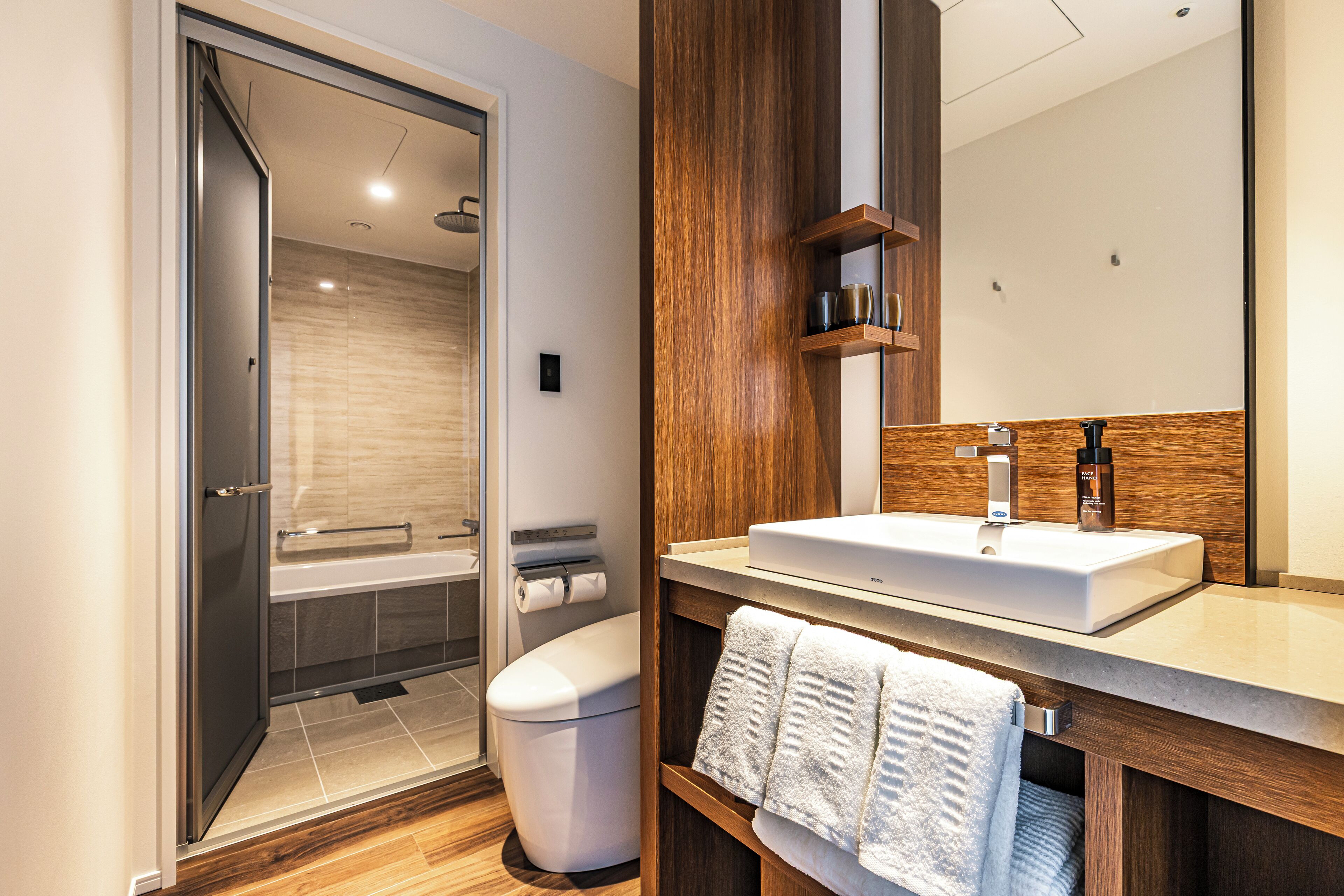 A modern bathroom with a shower, toilet, and sink.
