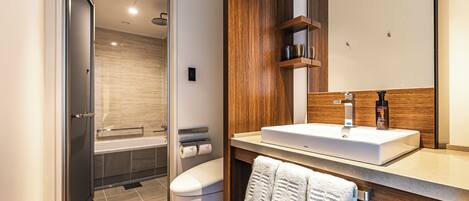 A modern bathroom with a shower, toilet, and sink.