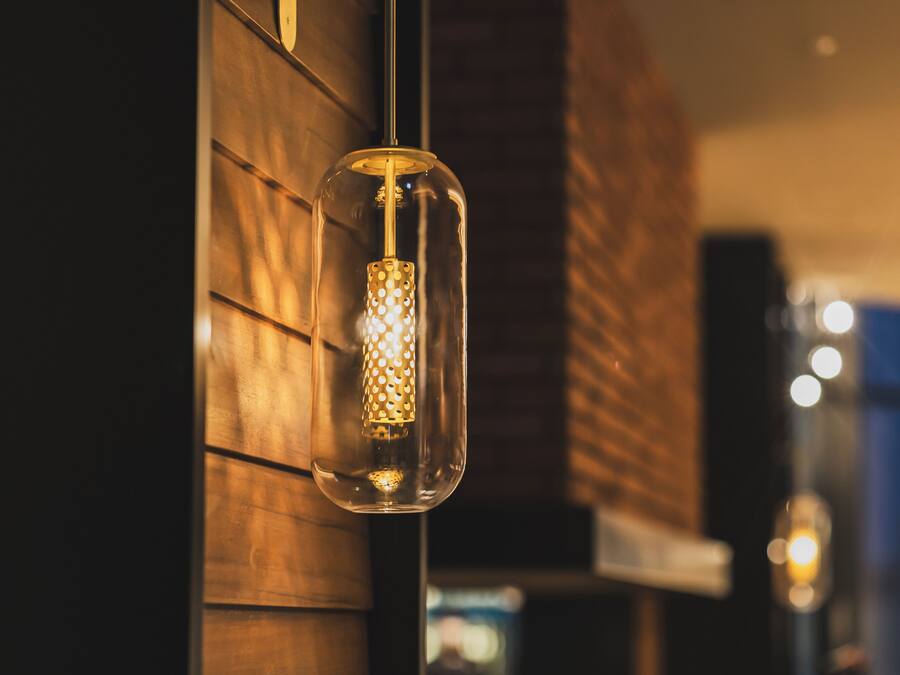 En pendel lampe med klart glas og en struktureret overflade indeni, hængt op i loftet.