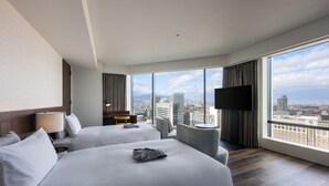 A hotel room with two beds, a TV, a city view, and a modern design. - THE GATE HOTEL SAPPORO by HULIC (Sapporo)