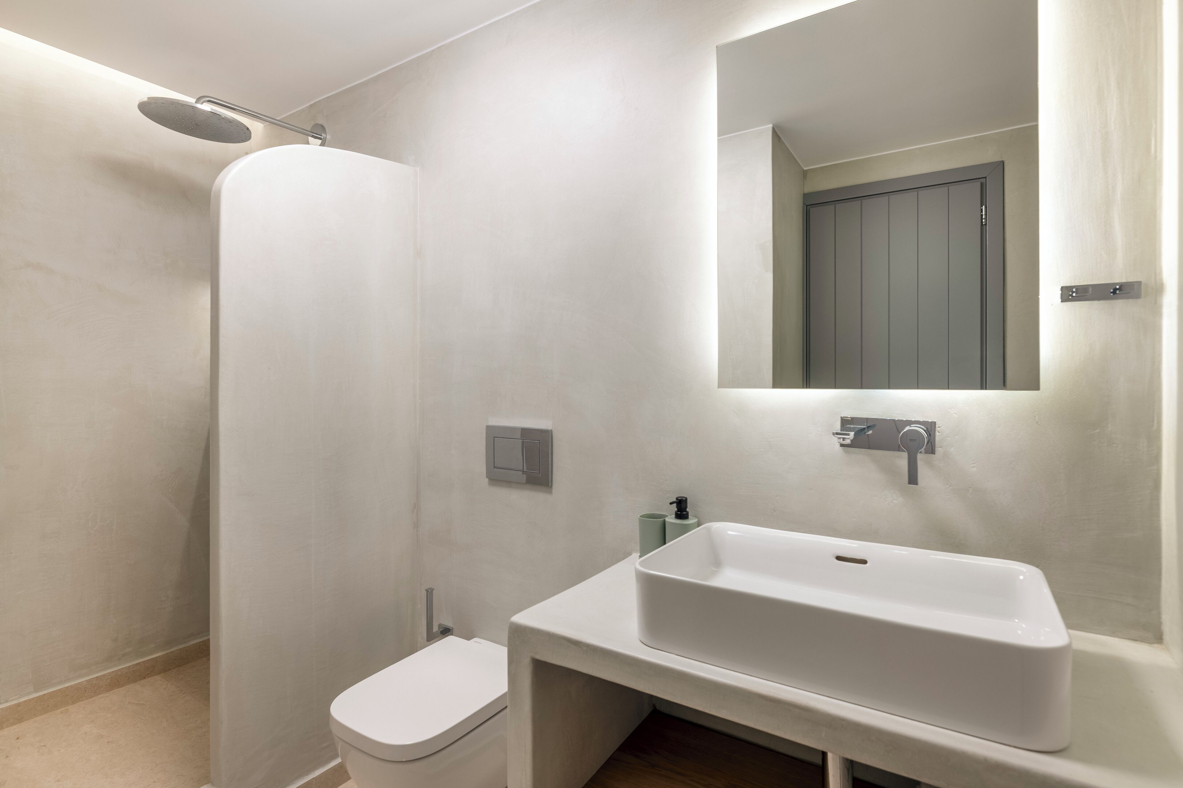 Un bagno moderno con doccia, WC e lavandino.
