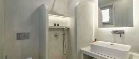 A modern bathroom with a toilet, shower, and sink.
