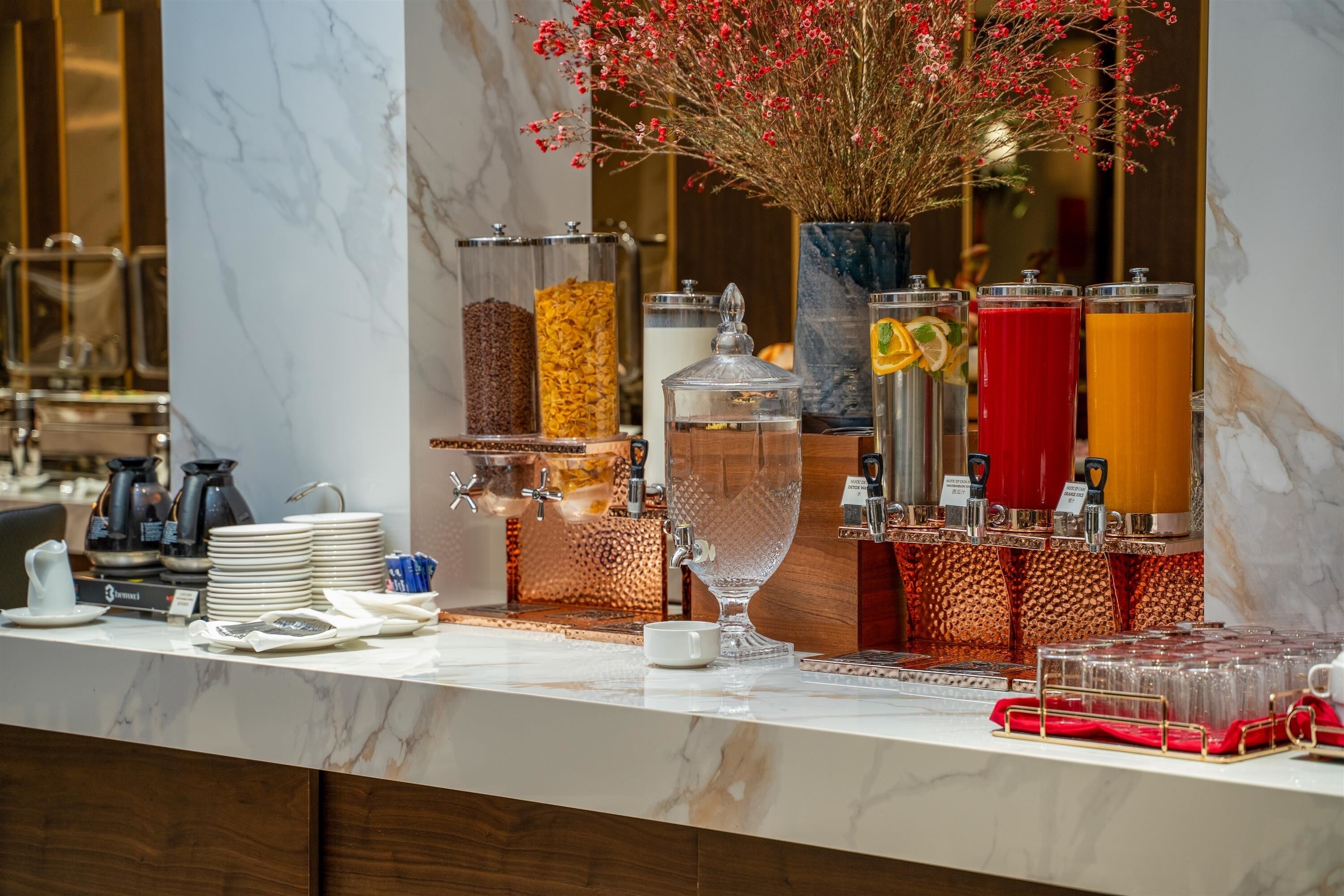 A breakfast bar with a marble countertop, a coffee station, and a variety of food and drink dispensers.