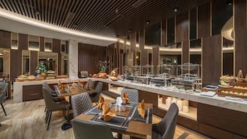 Un moderno comedor con barra libre, suelo de mármol y mobiliario contemporáneo.