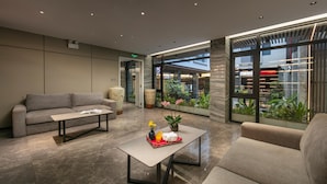 Een moderne lobby met een bank, een salontafel en een potplant.