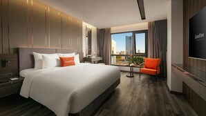 Een moderne hotelkamer met een groot bed, een bureau en een televisie.