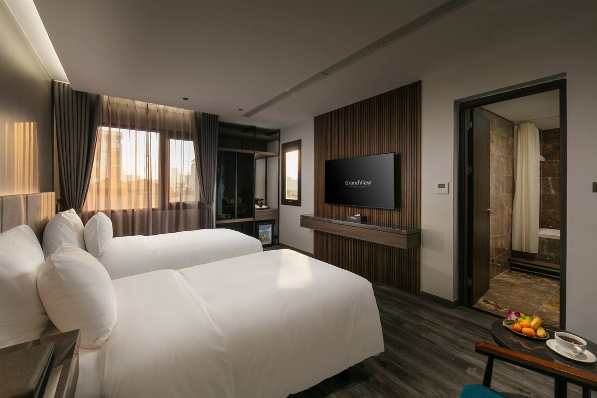 Deluxe Double or Twin Room, Bathtub | Living area | 55-inch Smart TV with premium channels
