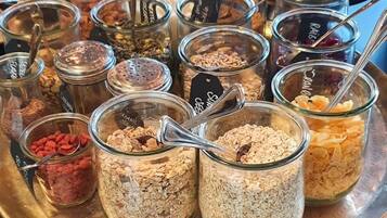 A buffet with various food options including fruits, cereals, and nuts.