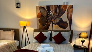 A hotel room with a large bed, two bedside tables, a floor lamp, a painting on the wall, and a carpeted floor. - STARMAX CİTY HOTEL'S YALOVA (Yalova)