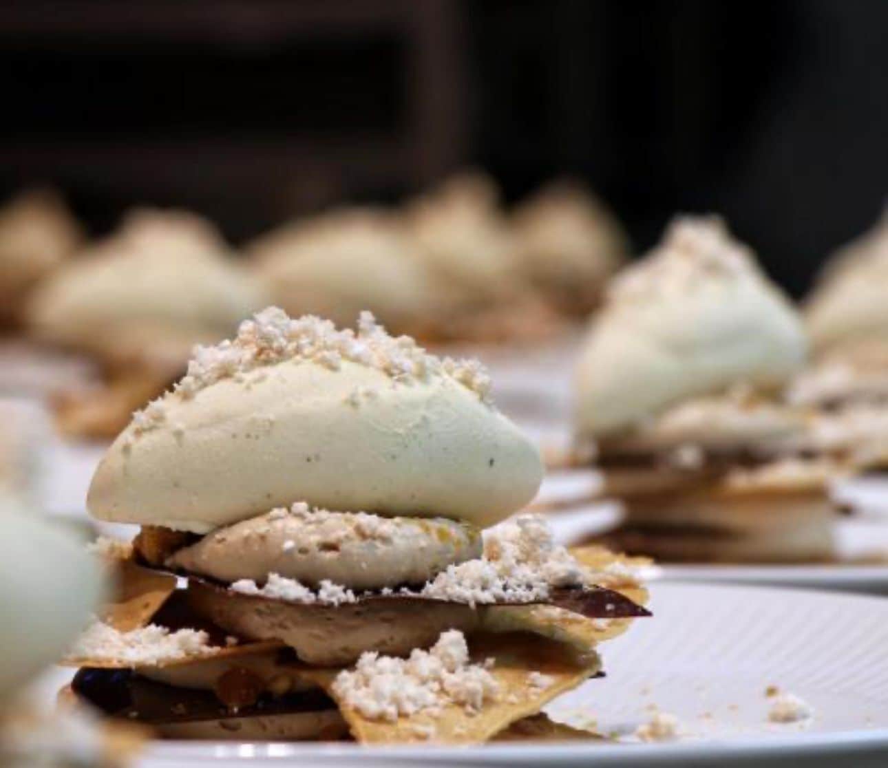 Postre con cobertura cremosa y nueces trituradas, servido en un plato.