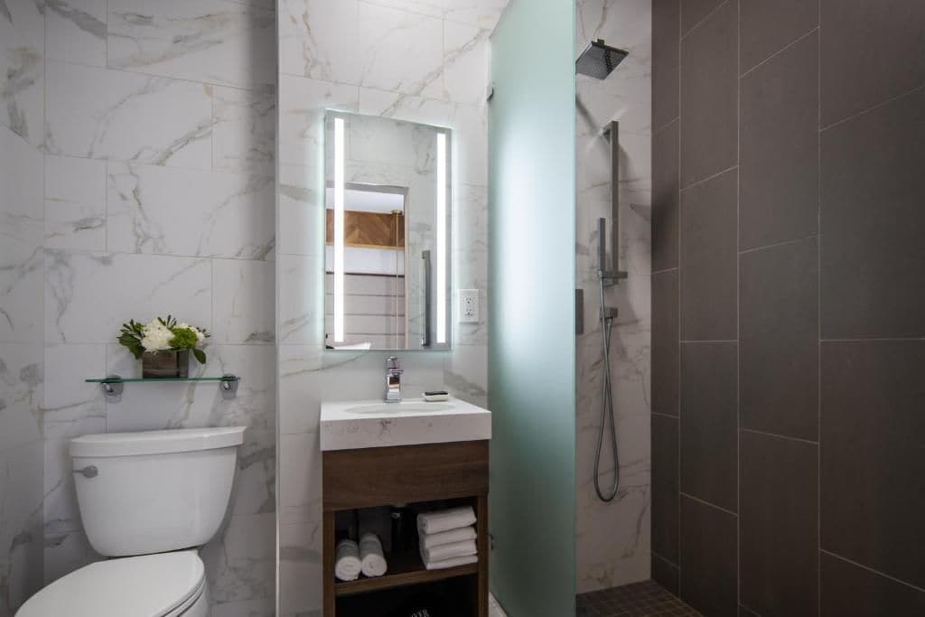 A modern bathroom with a toilet, sink, and shower.