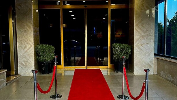 A hotel entrance with a red carpet, glass doors, and potted plants. - STARMAX CİTY HOTEL'S YALOVA (Yalova)