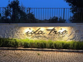 Fachada de hotel de piedra con barandilla metálica.