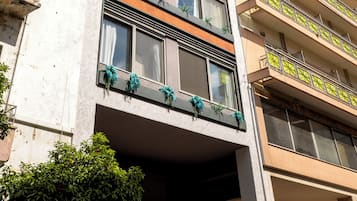 Un edificio de varios pisos con balcones, ventanas amplias y un cielo despejado.