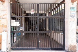 A gated entrance with a no entry sign, a bulletin board, and a sign indicating a wet floor. - Appartamento Arianna (Bari)