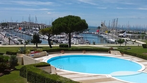 A swimming pool with a view of a marina and boats. - Beautiful apartment with terrace for 4 people, near beach in Port Camargue (Port Camargue)